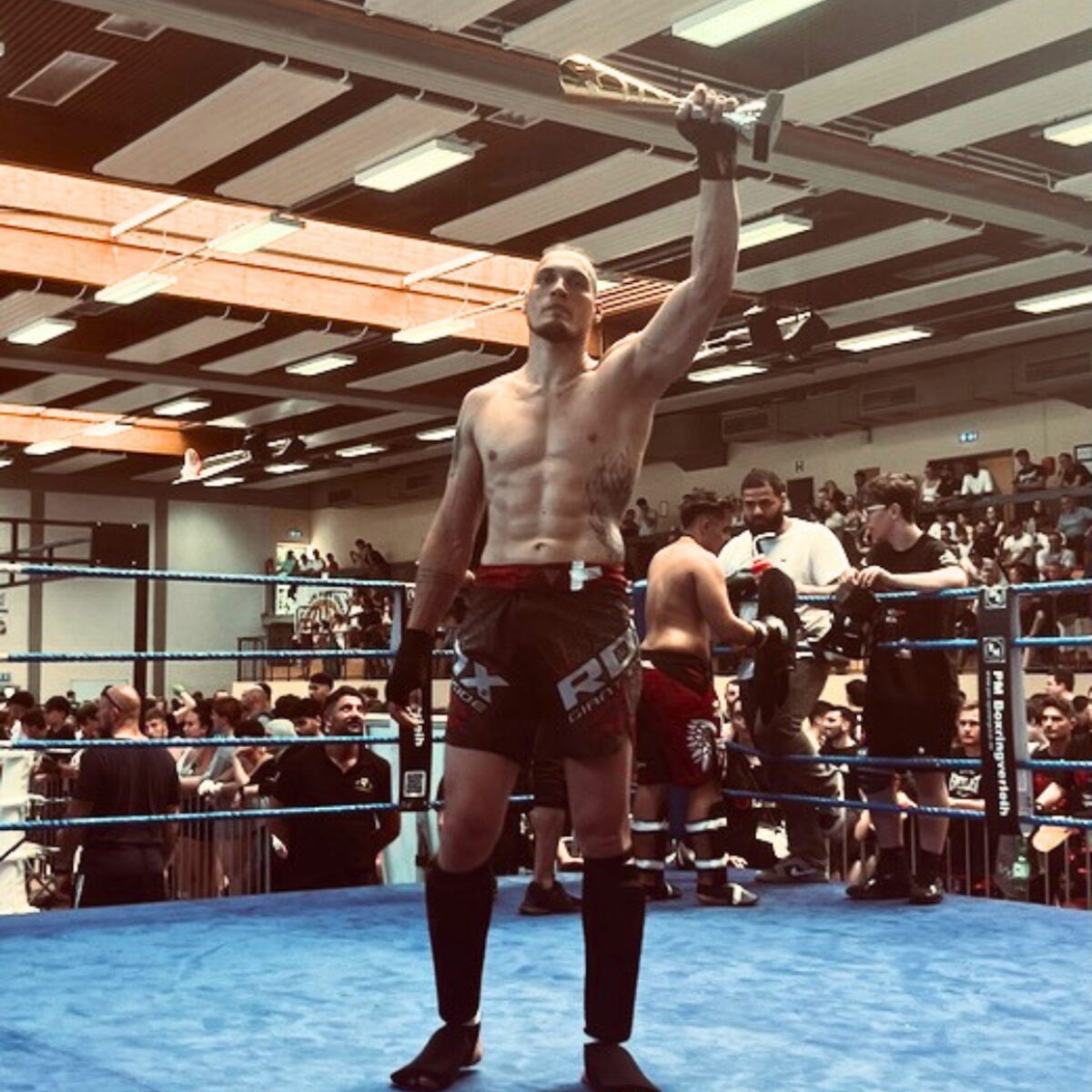 Bero Klahr im Boxring mit Pokal nach einem Wettkampfsieg